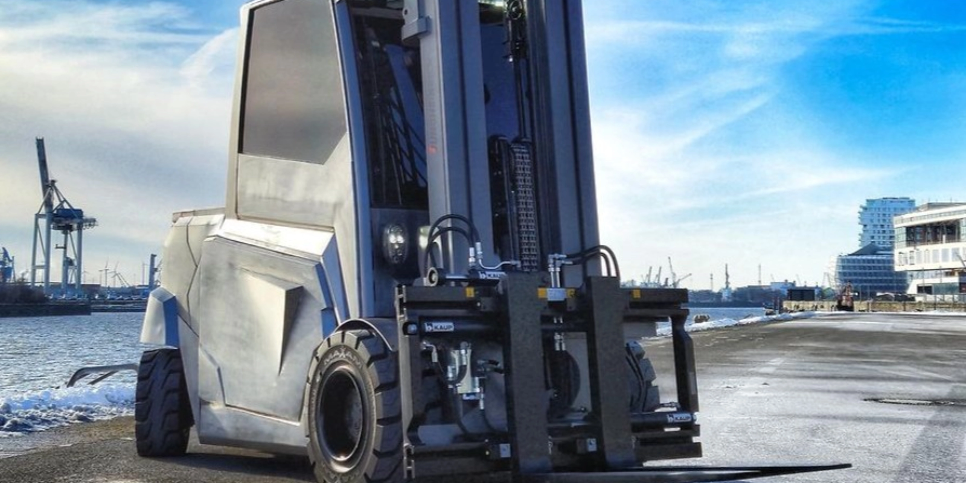 Large industrial forklift parked at a harbor loading area.