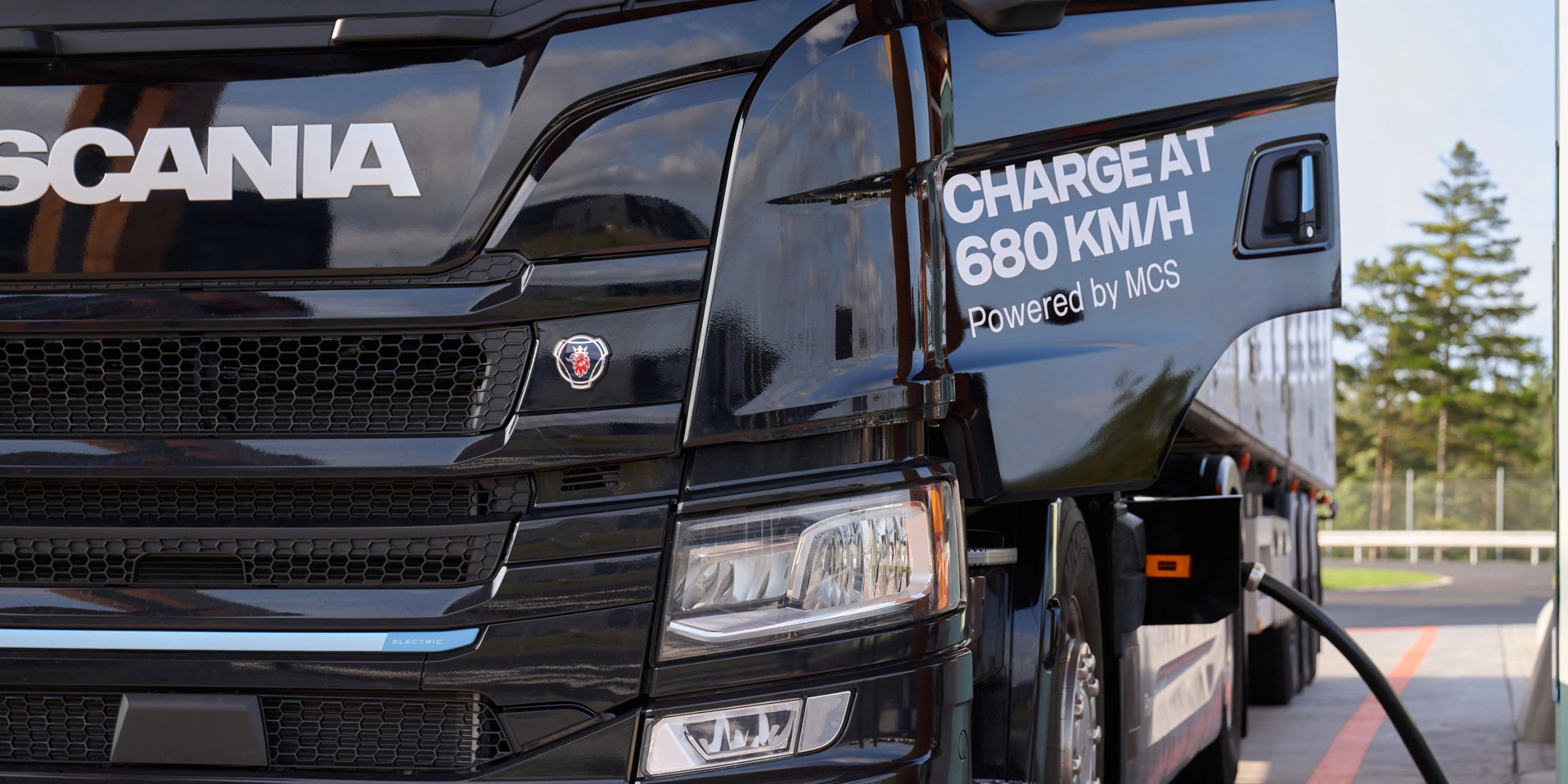 Scania Elektro-Lkw lädt an Station mit angeschlossenem Kabel.