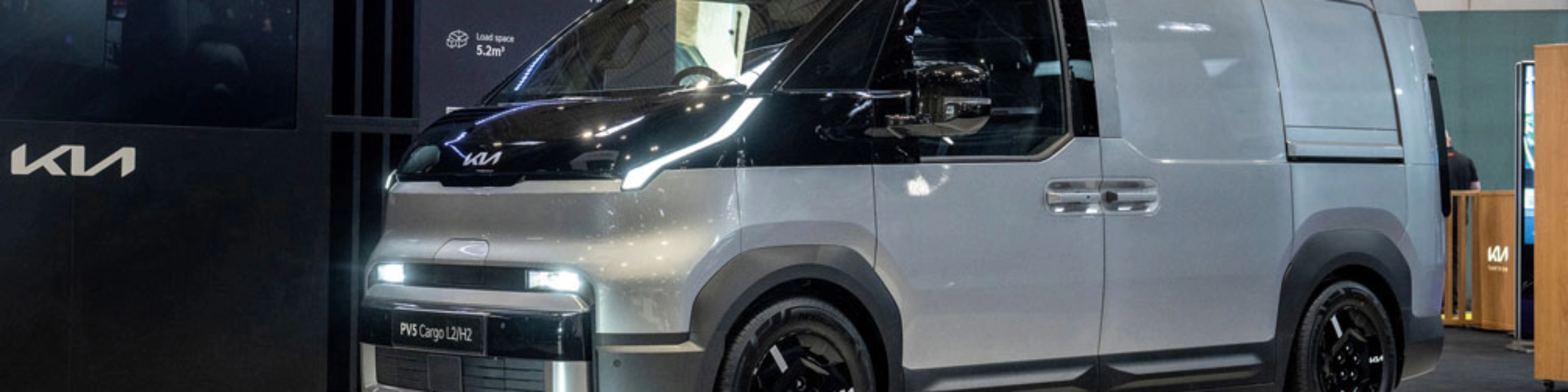 Kia PV5 Cargo van displayed at an indoor exhibition stand.