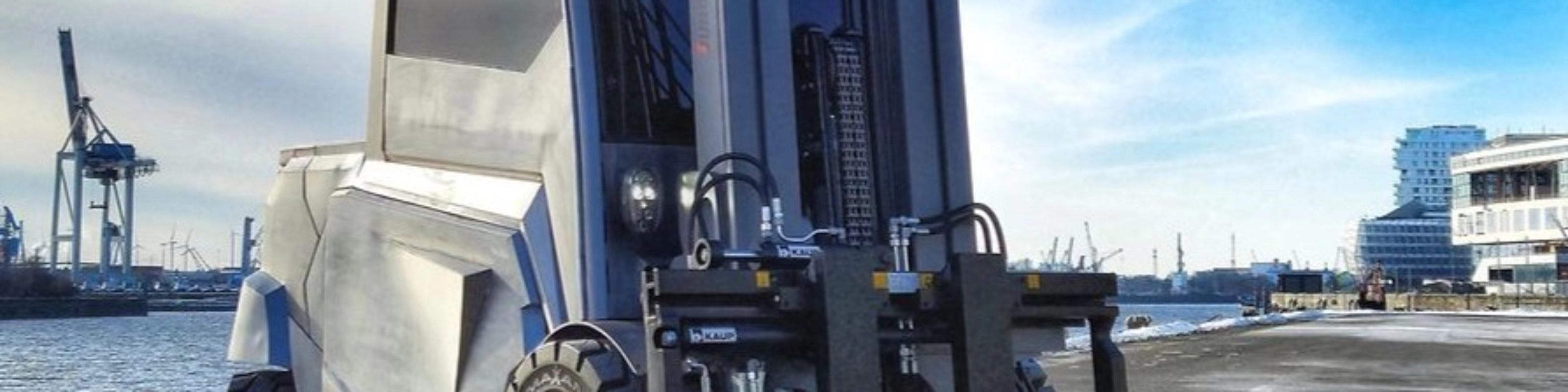 Large industrial forklift parked at a harbor loading area.