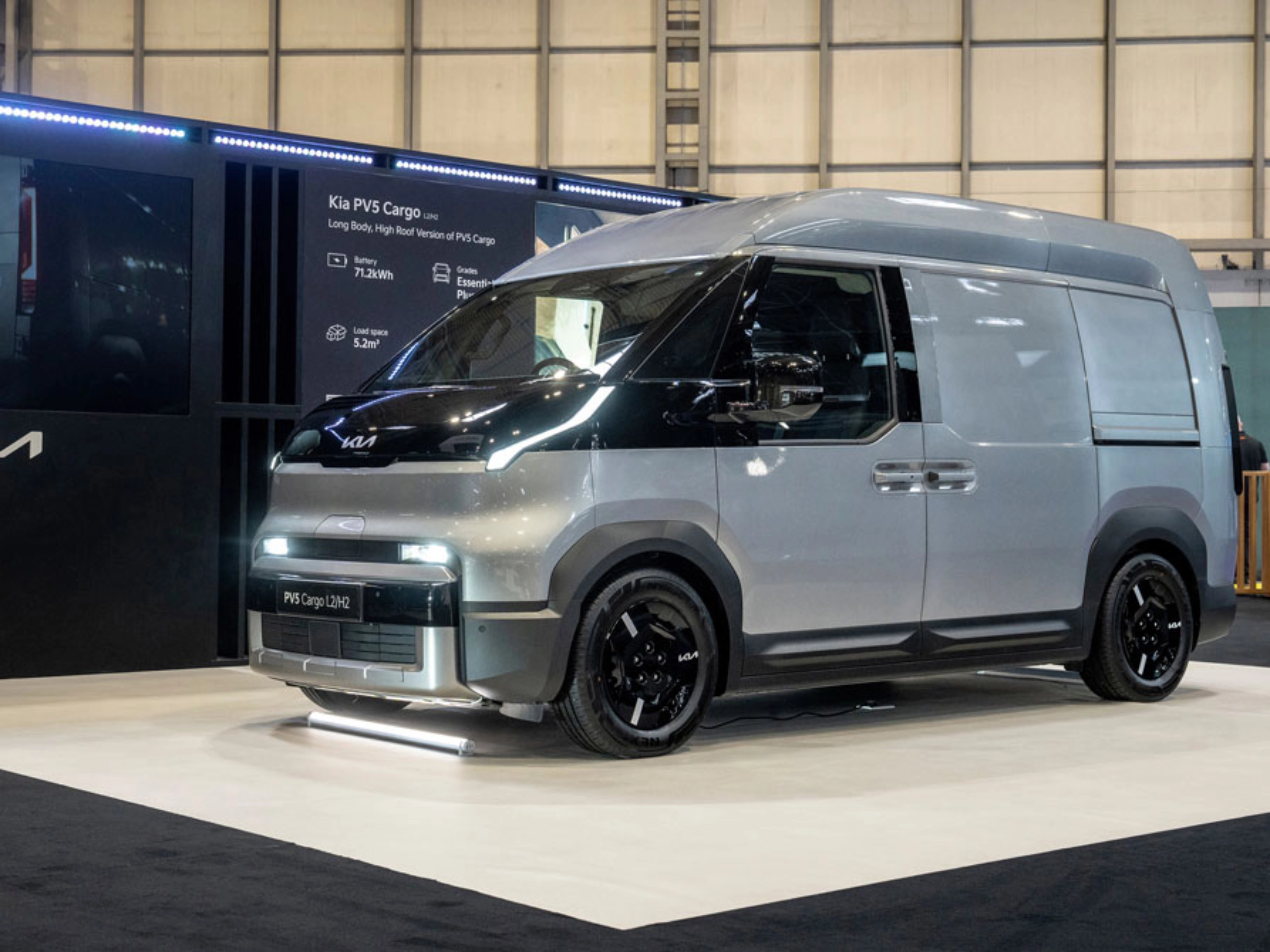 Kia PV5 Cargo van displayed at an indoor exhibition stand.