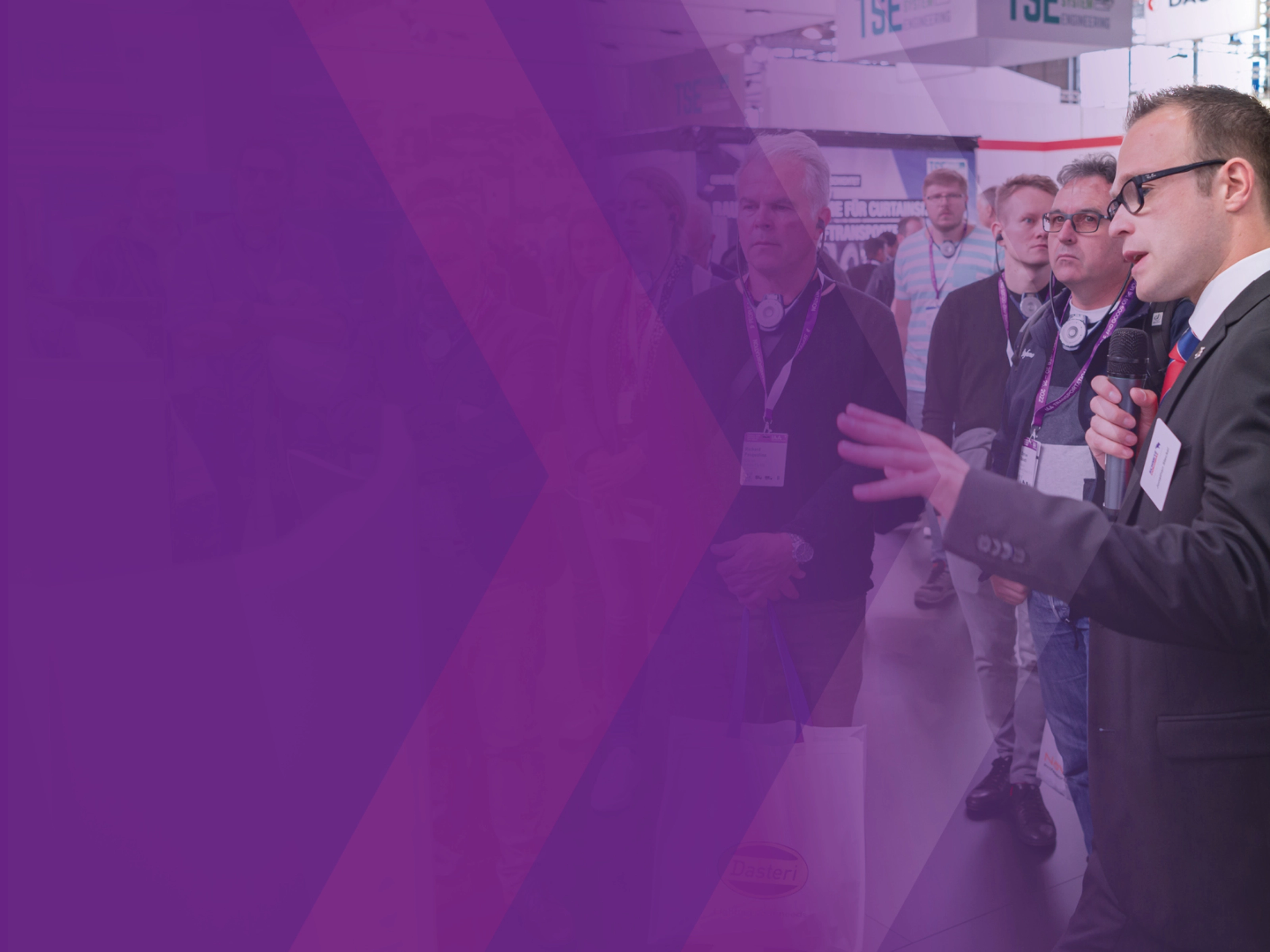 Ein Referent spricht während einer geführten Tour zu einer Gruppe auf einer Messe.