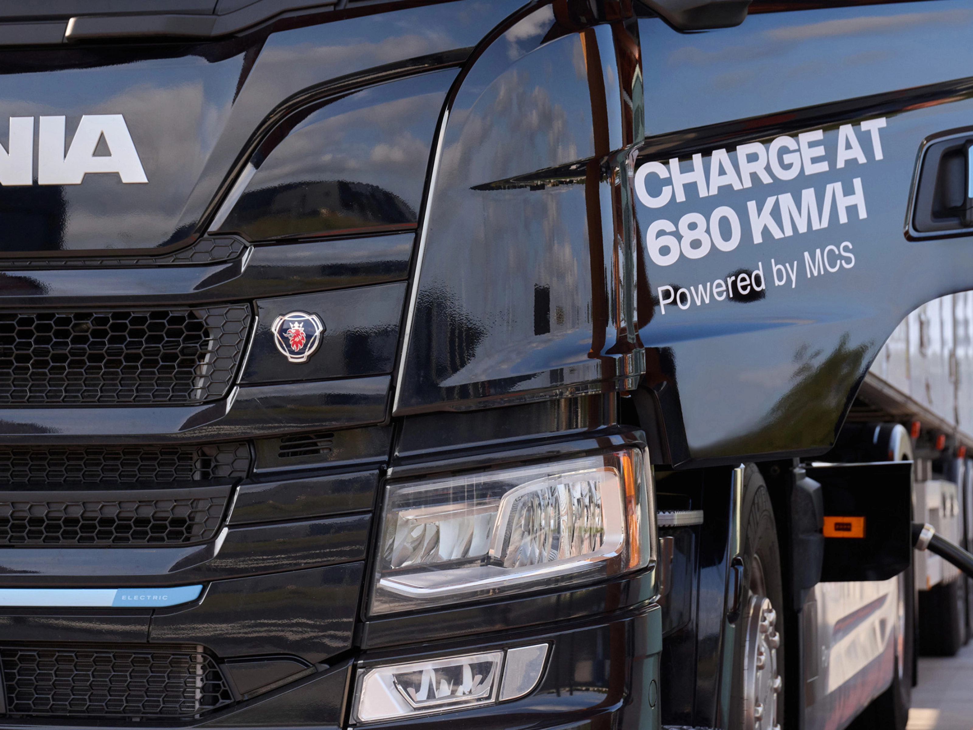 Scania Elektro-Lkw lädt an Station mit angeschlossenem Kabel.
