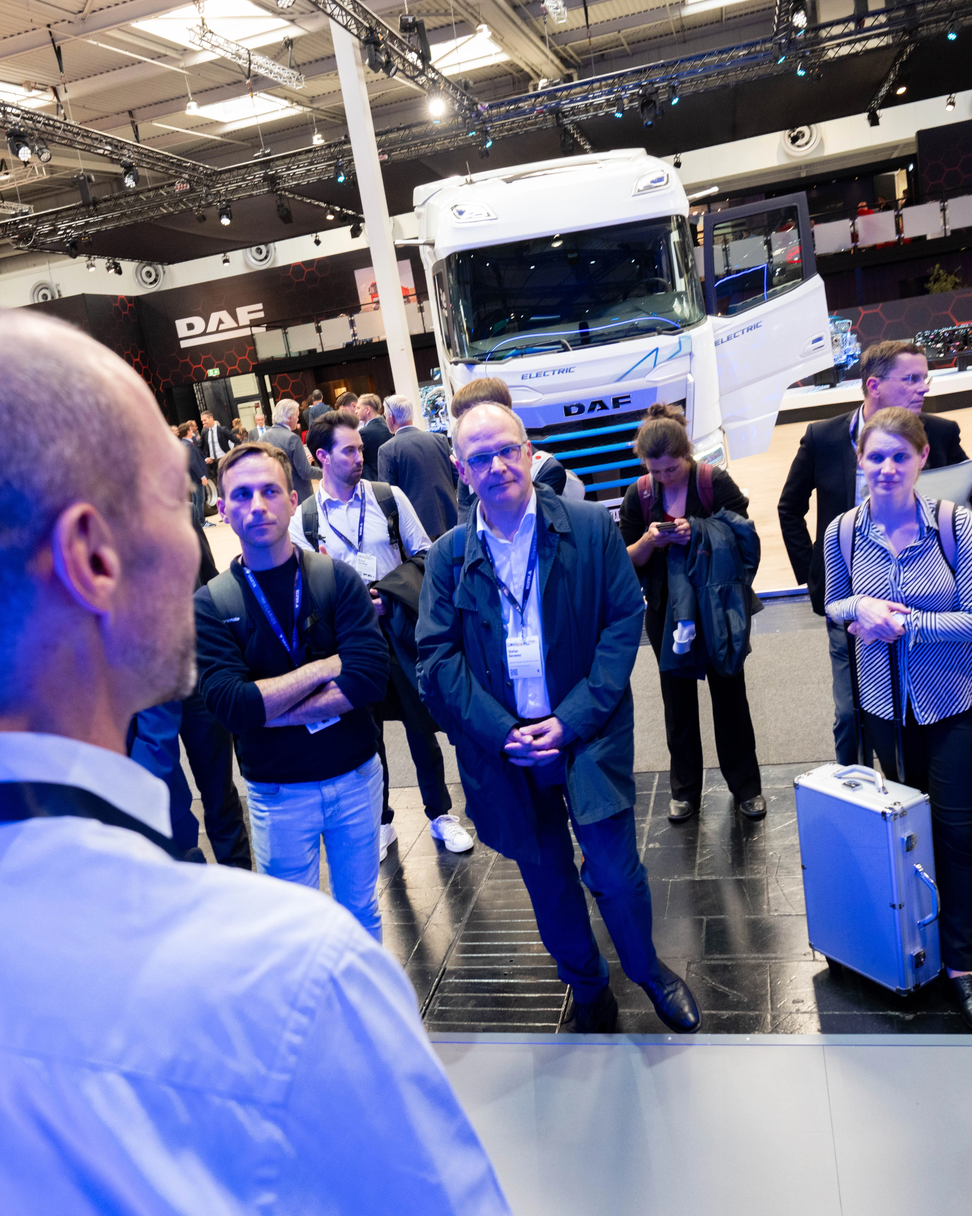 Besucher verfolgen eine Präsentation am DAF-Lkw-Messestand.