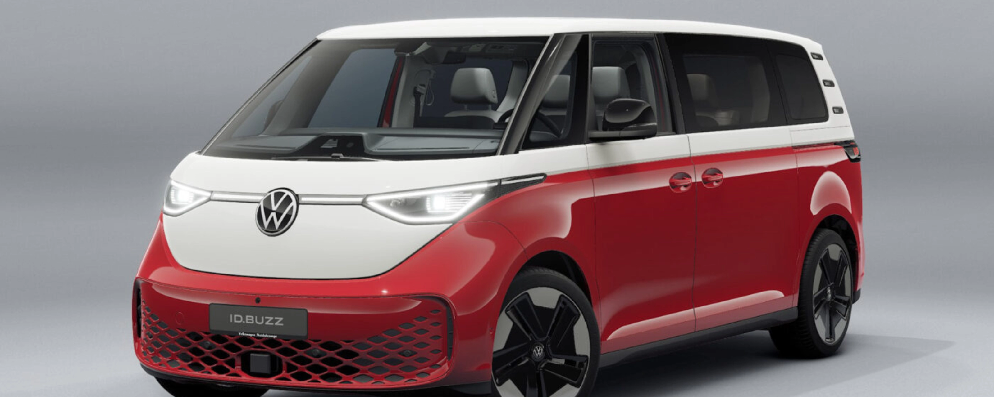 Rot-weißer Volkswagen Van in Frontansicht vor neutralem Studiohintergrund.