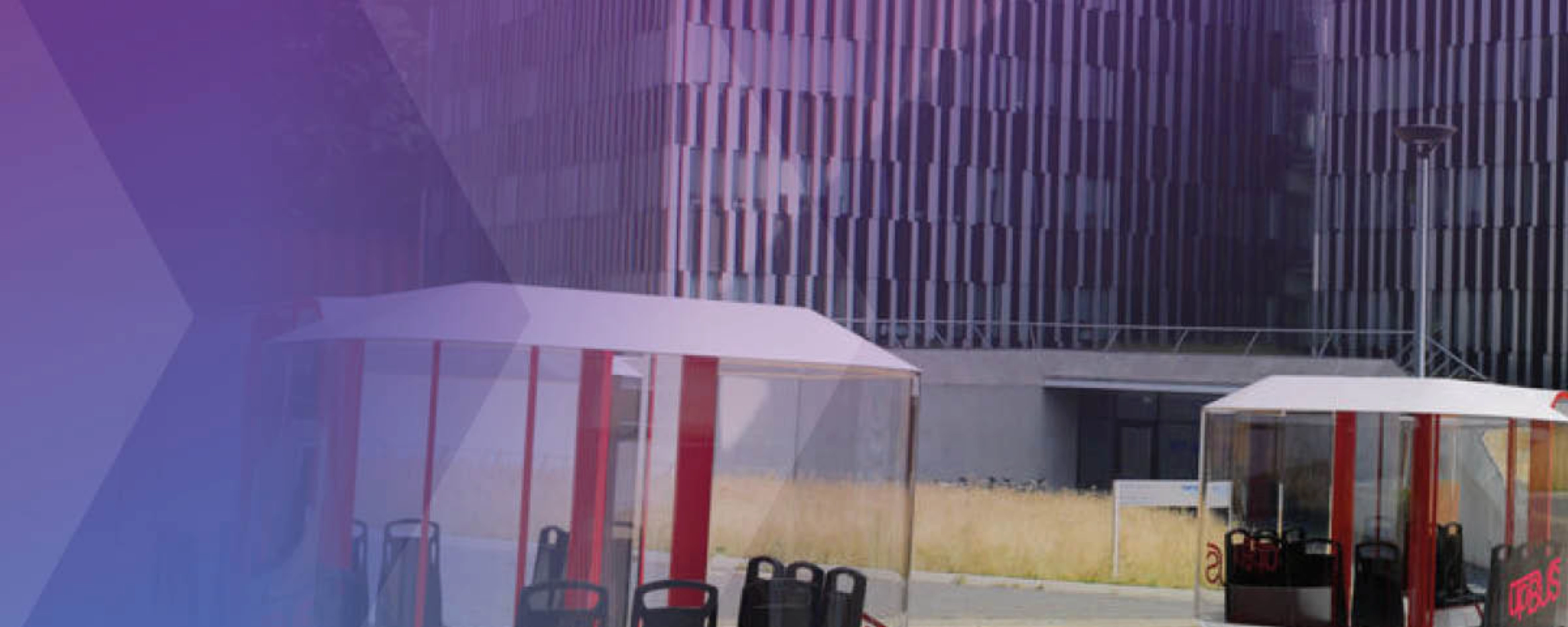 Several futuristic cable cars and ground pods are shown near a modern office building.