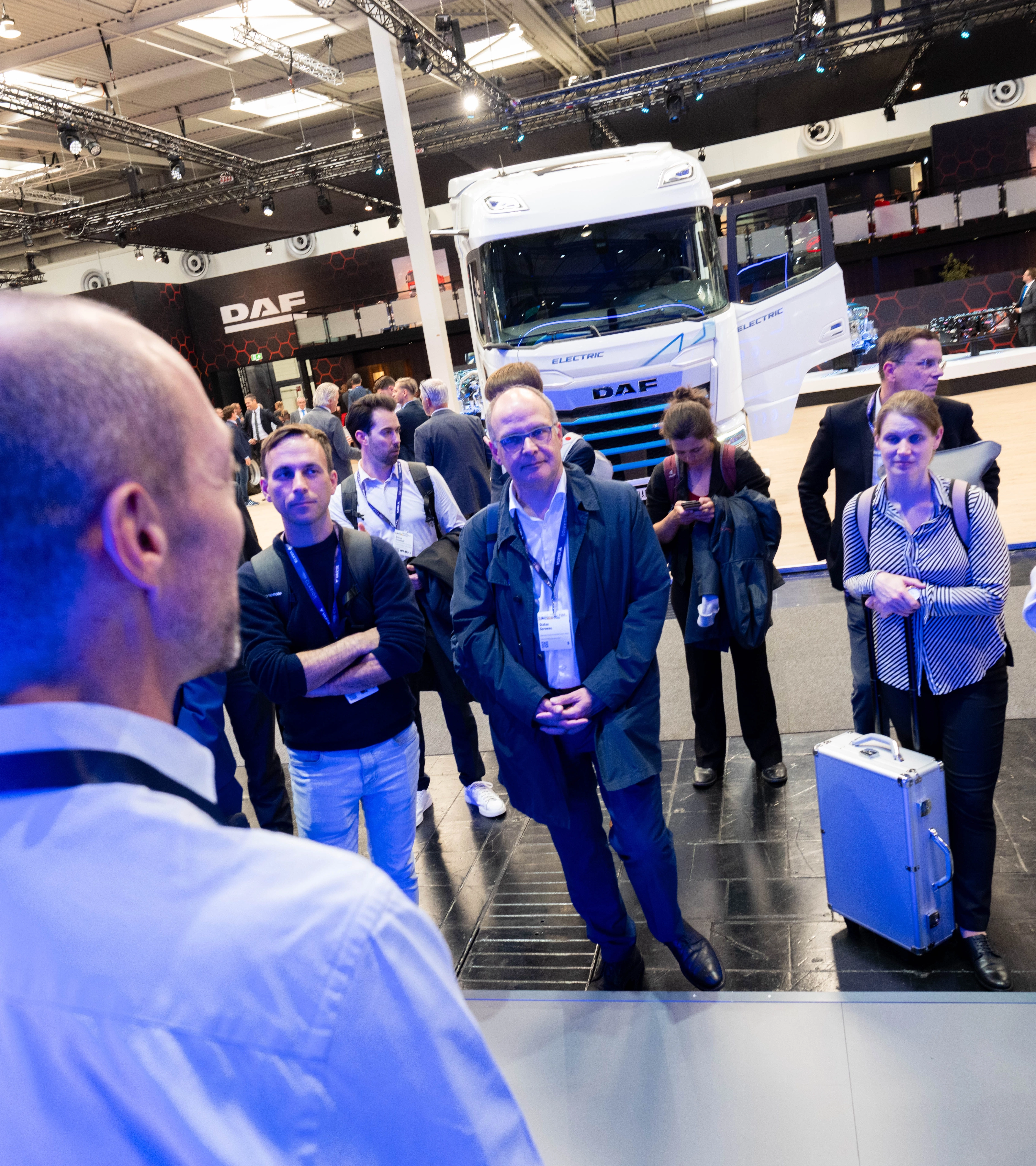 Besucher verfolgen eine Präsentation am DAF-Lkw-Messestand.