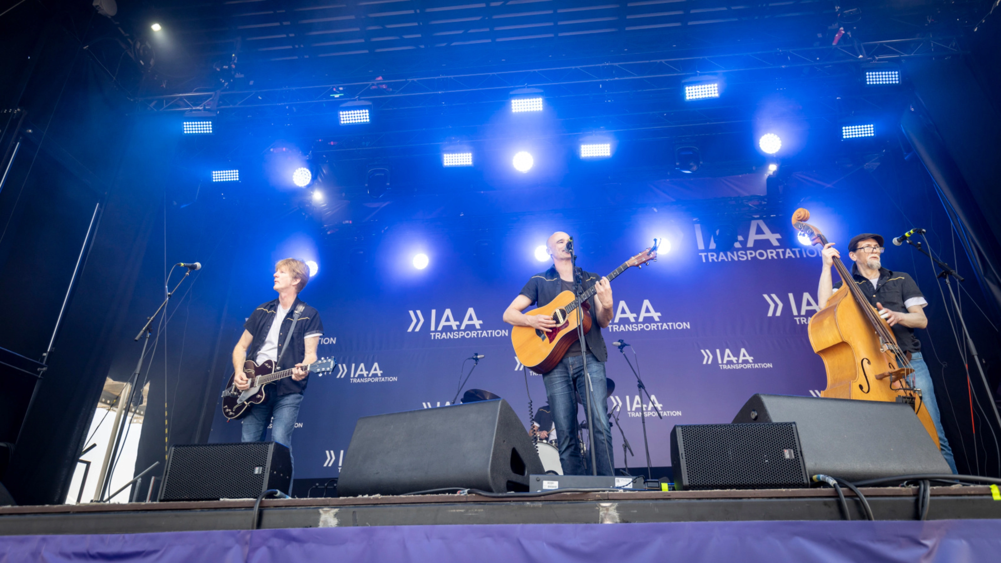Band spielt live auf einer Freiluftbühne bei einer Veranstaltung.