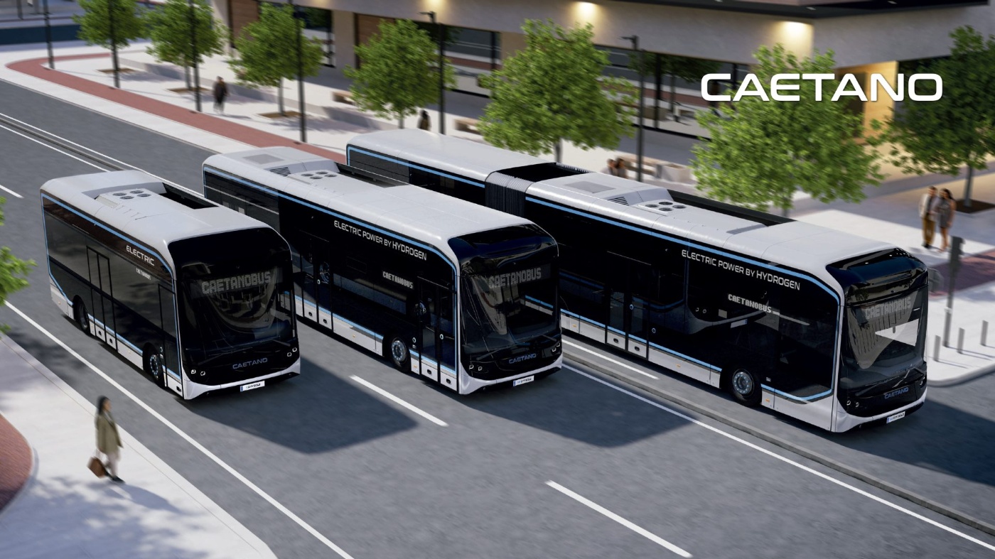 Drei Caetano-Elektro- und Wasserstoffbusse auf einer Stadtstraße neben einem modernen Gebäude.