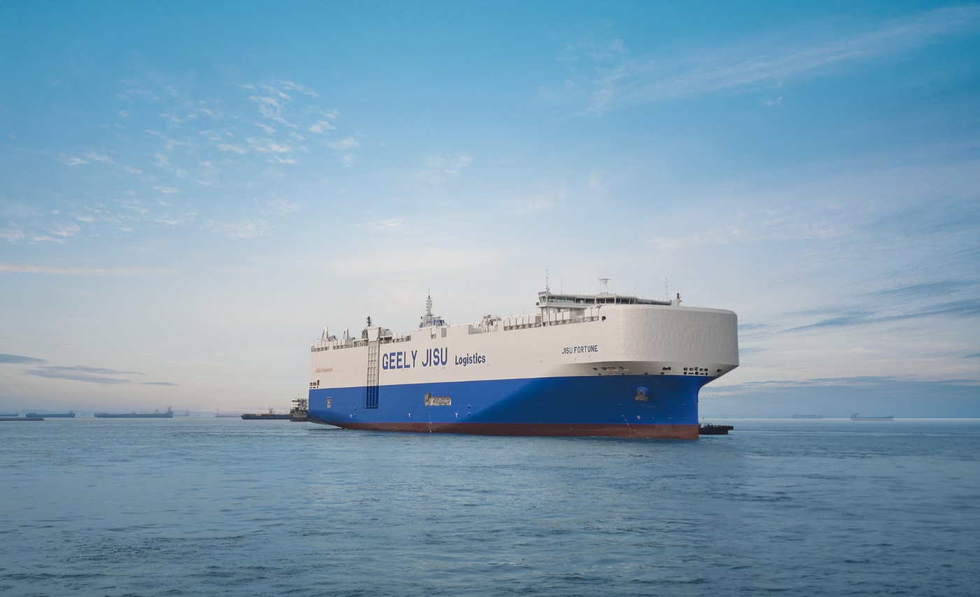 Großes Frachtschiff mit Geely Jisu-Aufschrift fährt auf ruhigem Meer unter blauem Himmel.