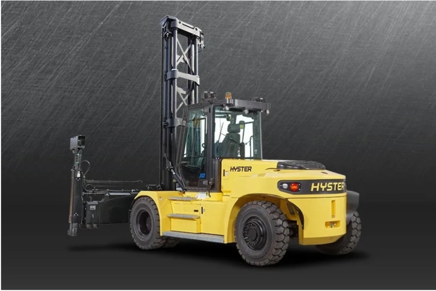 Yellow Hyster forklift truck with vertical lifting mast on a dark industrial background.