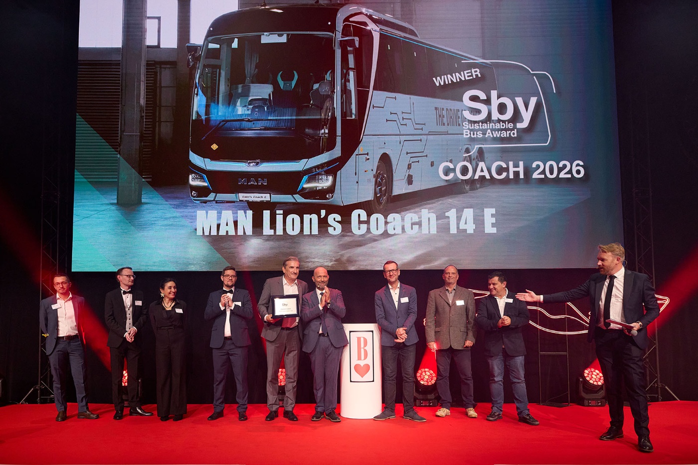 A group celebrates on stage as MAN Lion’s Coach 14 E wins the 2026 Sustainable Bus Award.