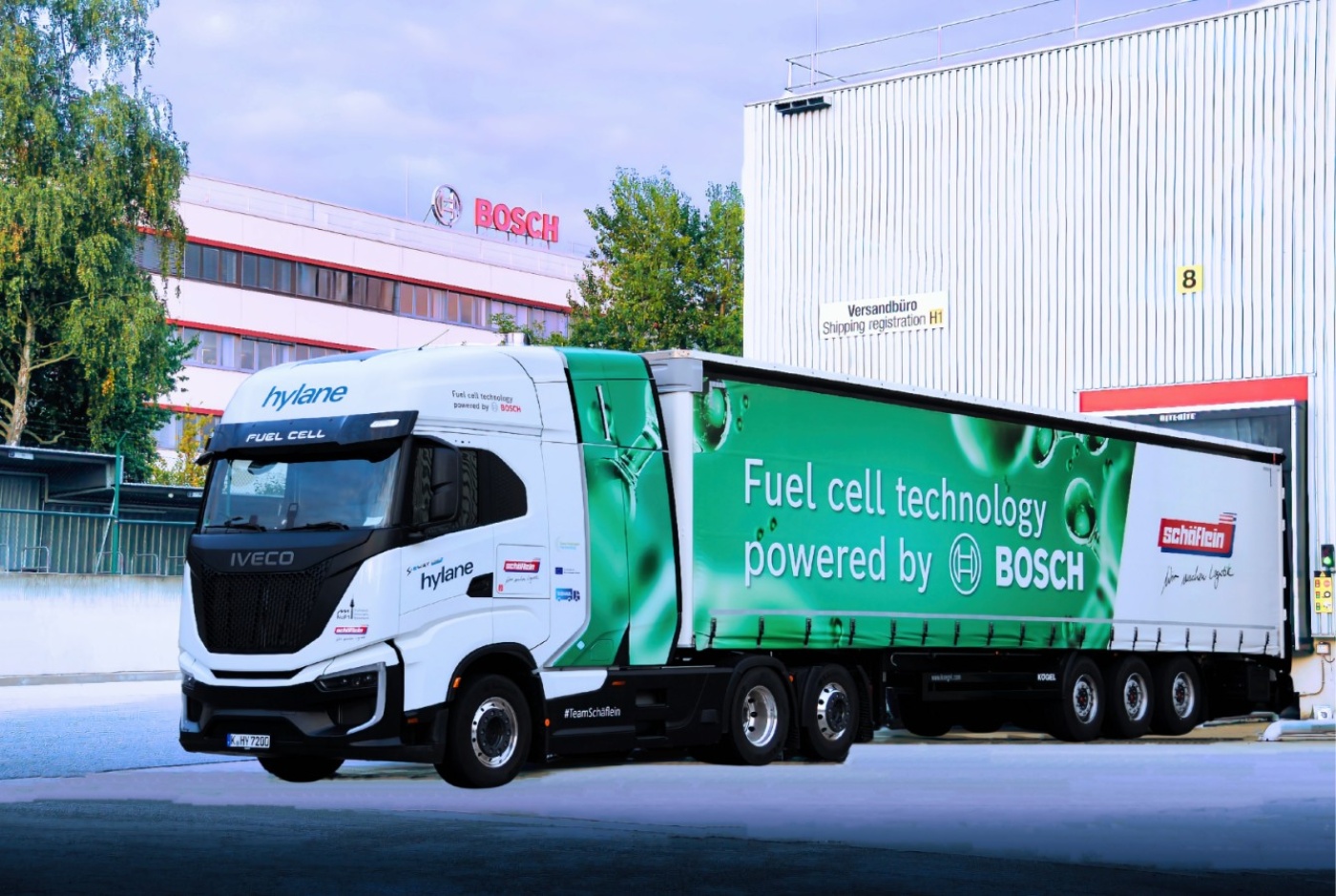 Wasserstoffbetriebener Lkw mit BOSCH-Branding vor einer Versandhalle geparkt.