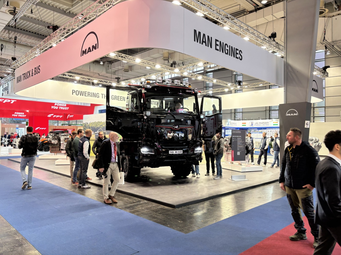 Großer MAN-Lkw steht auf einer Messefläche, umgeben von Besuchern und Ausstellern.