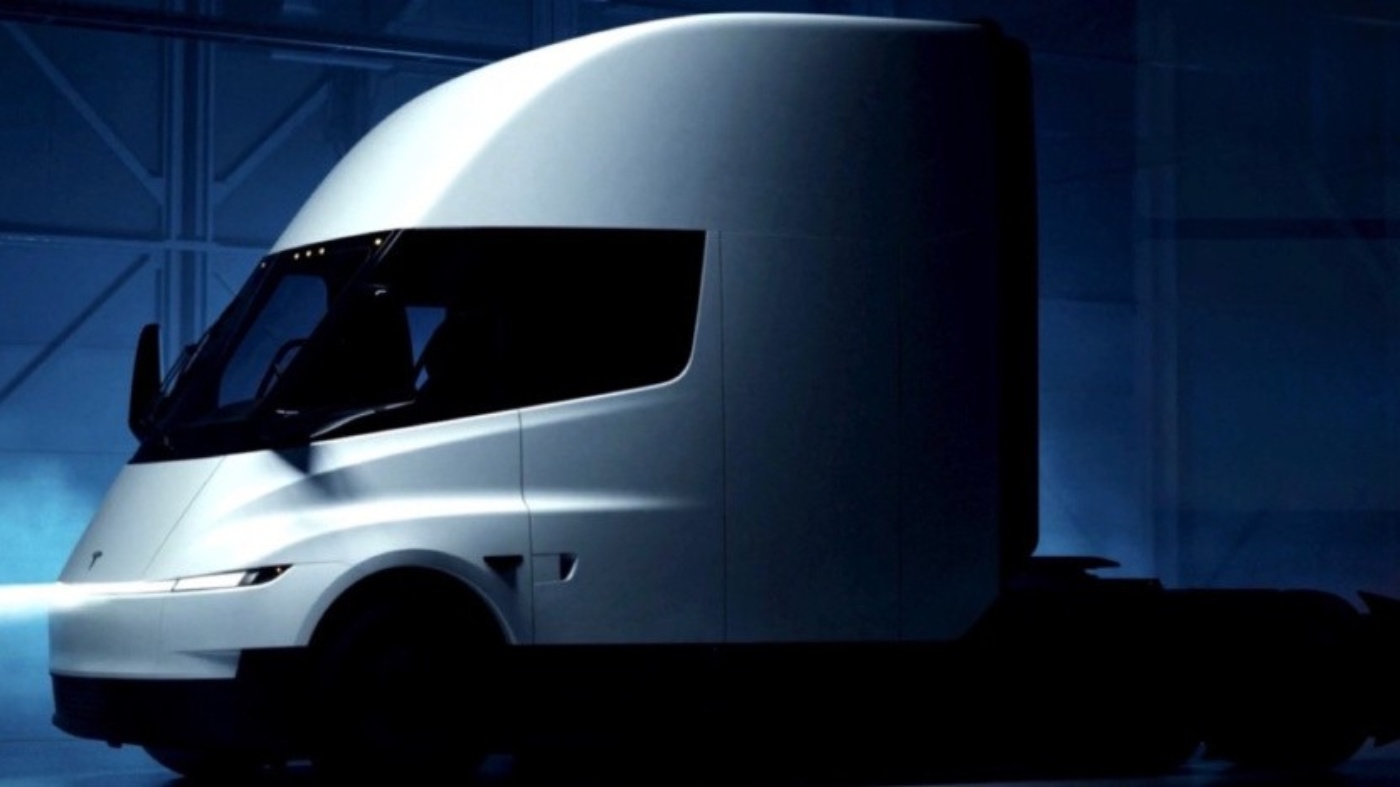 Futuristischer Tesla-Sattelschlepper in dunkler, industrieller Umgebung.