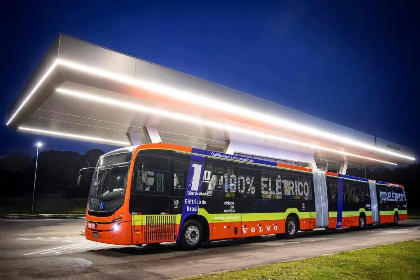 Gelenkiger Elektrobus von Volvo lädt nachts an einer modernen Ladestation.