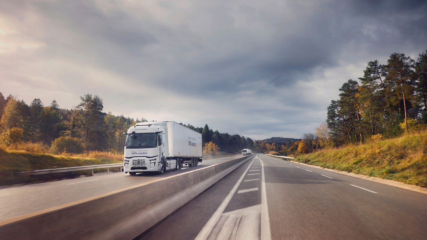 Ein elektrischer Renault-Lkw fährt auf einer Autobahn durch eine bewaldete Gegend bei Wolken.