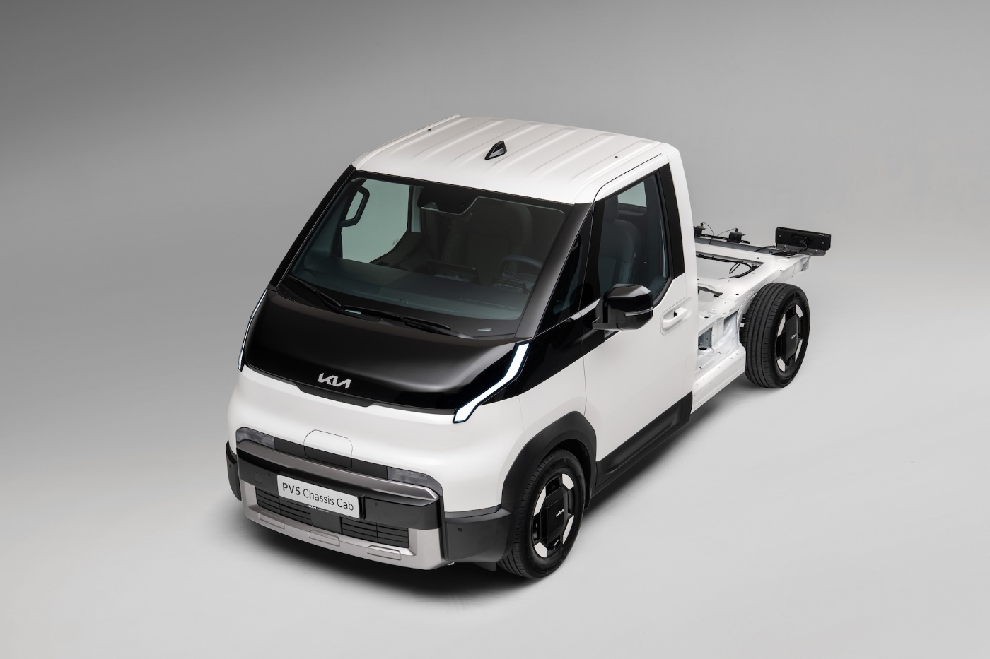 Ein elektrischer Renault-Lkw fährt auf einer Autobahn durch eine bewaldete Gegend bei Wolken.