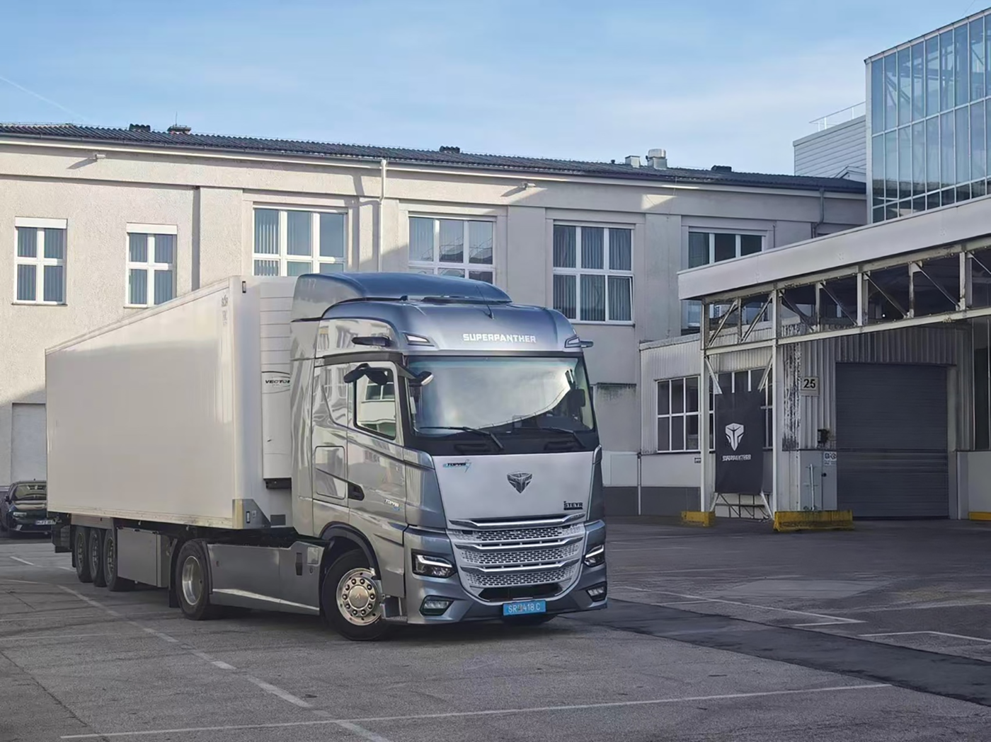 Ein silberner Lkw mit der Aufschrift „Superpanther“ steht vor einem Industriegebäude.
