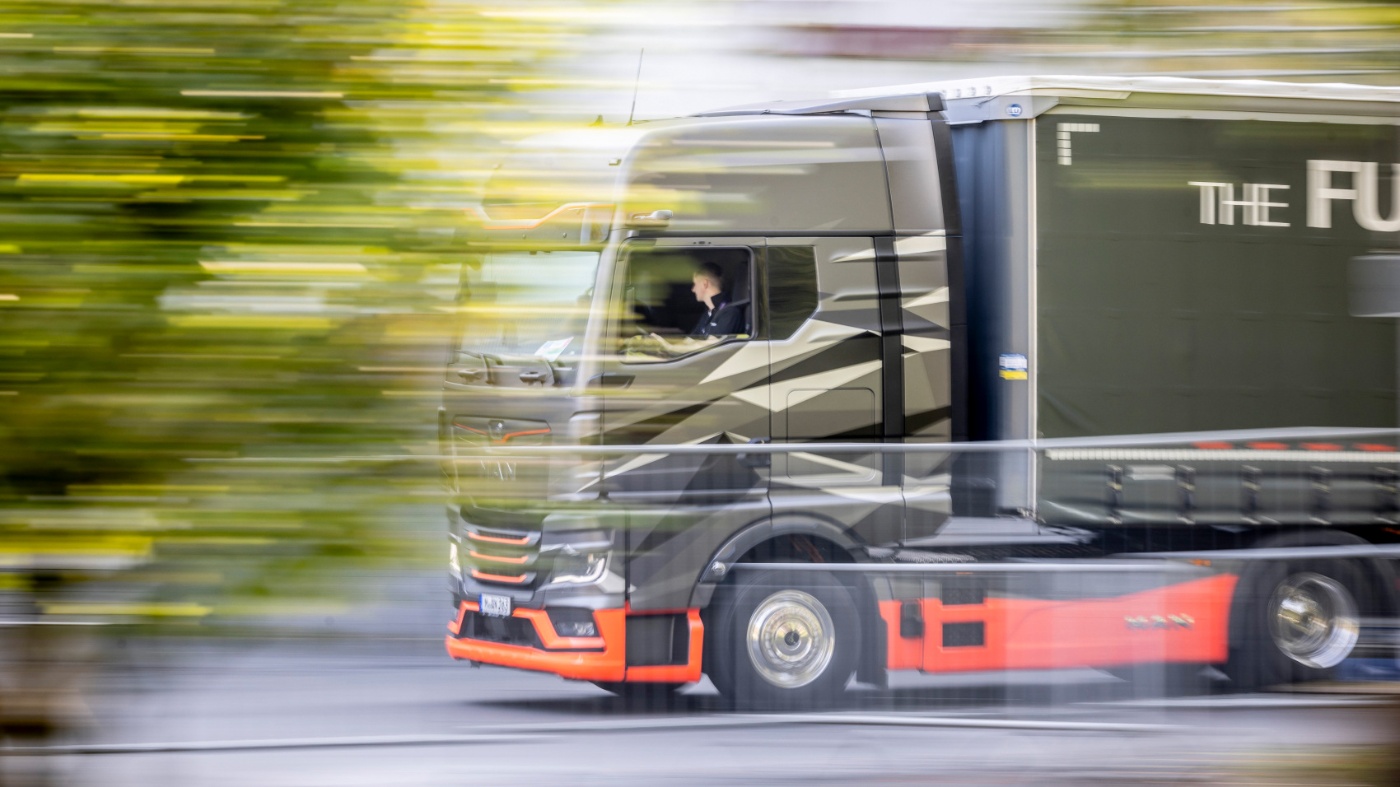 Moderner Lkw fährt auf einer Straße, aufgenommen mit Bewegungsunschärfe.
