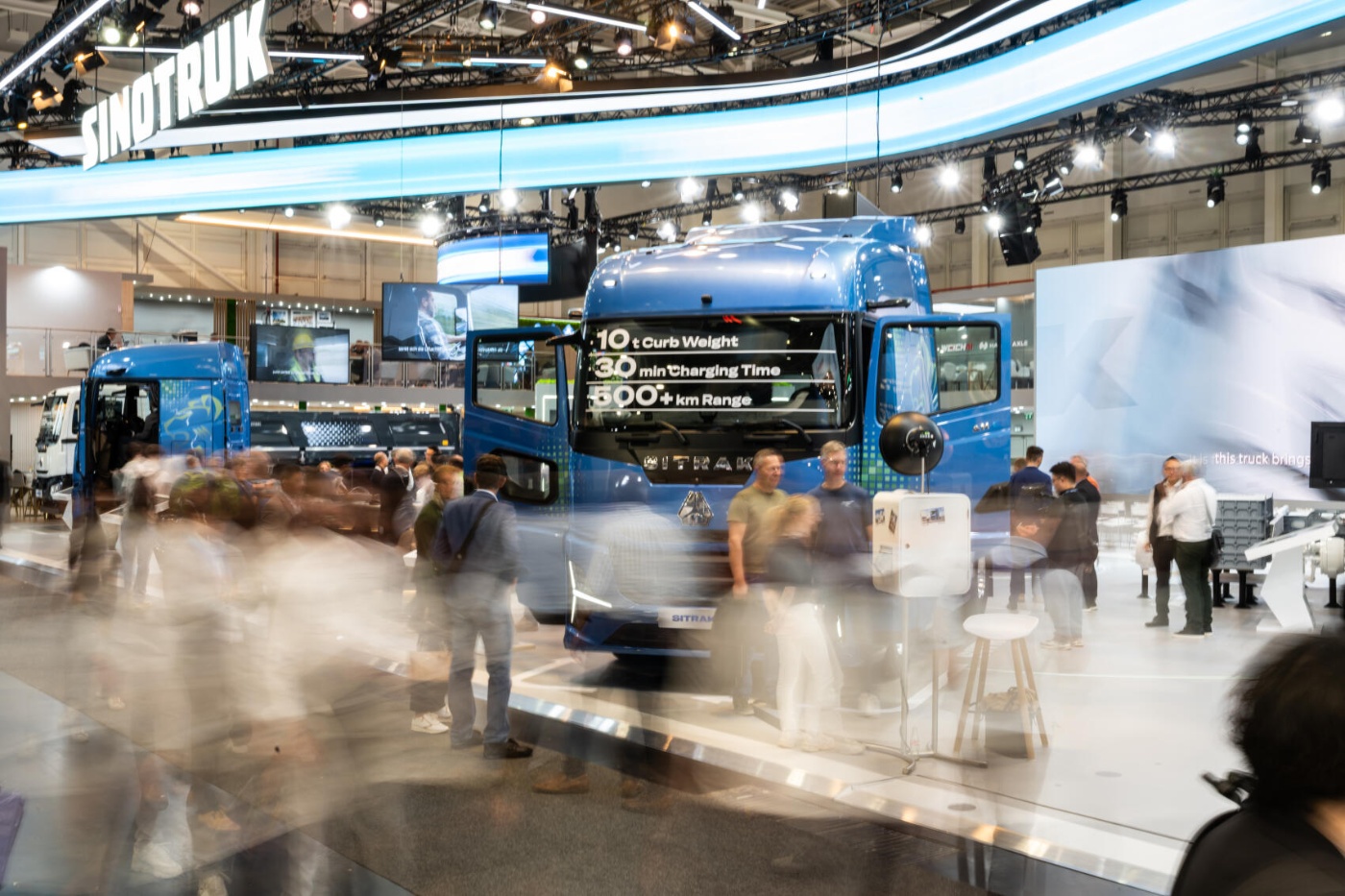 Besucher und Nutzfahrzeuge in einer gut besuchten IAA-Messehalle.