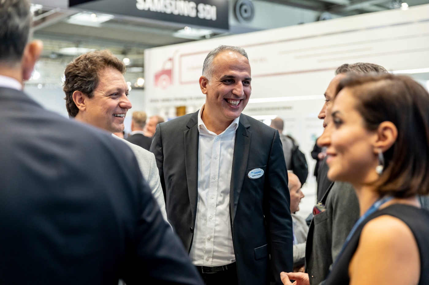 Geschäftsleute im Gespräch an einem Messestand.