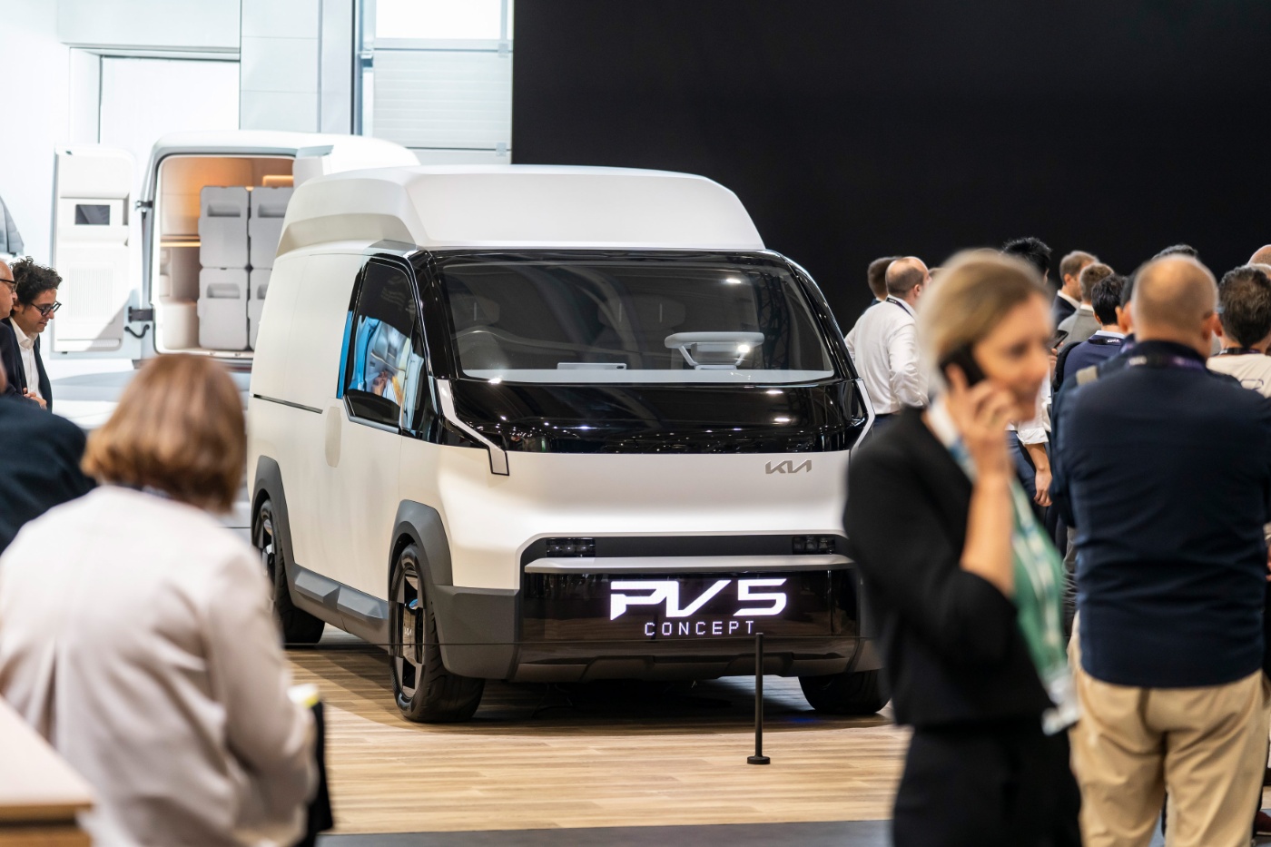 Weißer Kia PV5 Transporter auf einem Messestand.