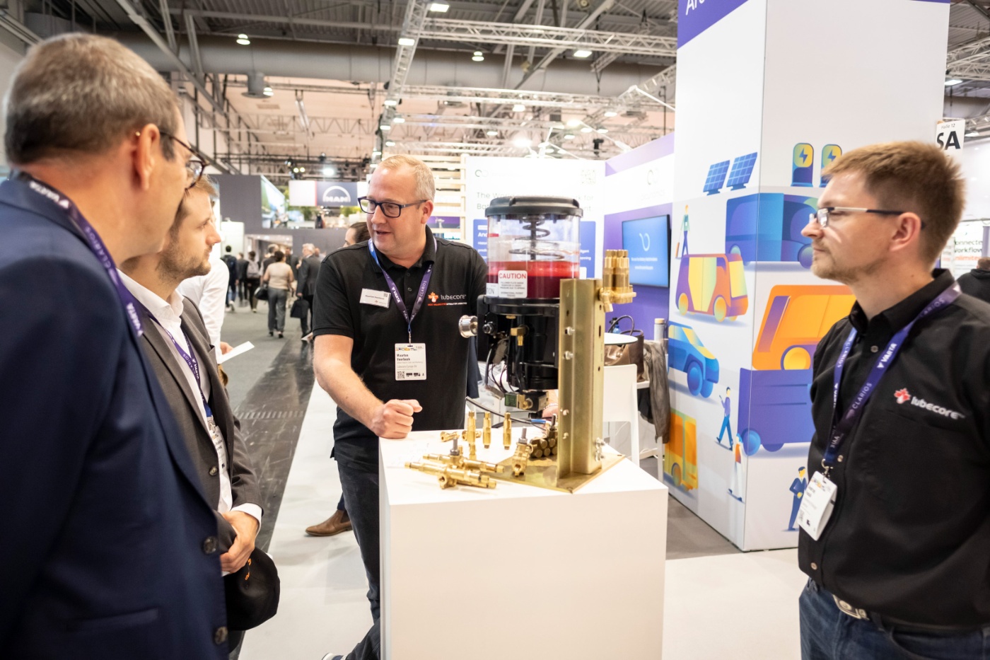 Mann erklärt ein Modell an einem Messestand Besuchern.