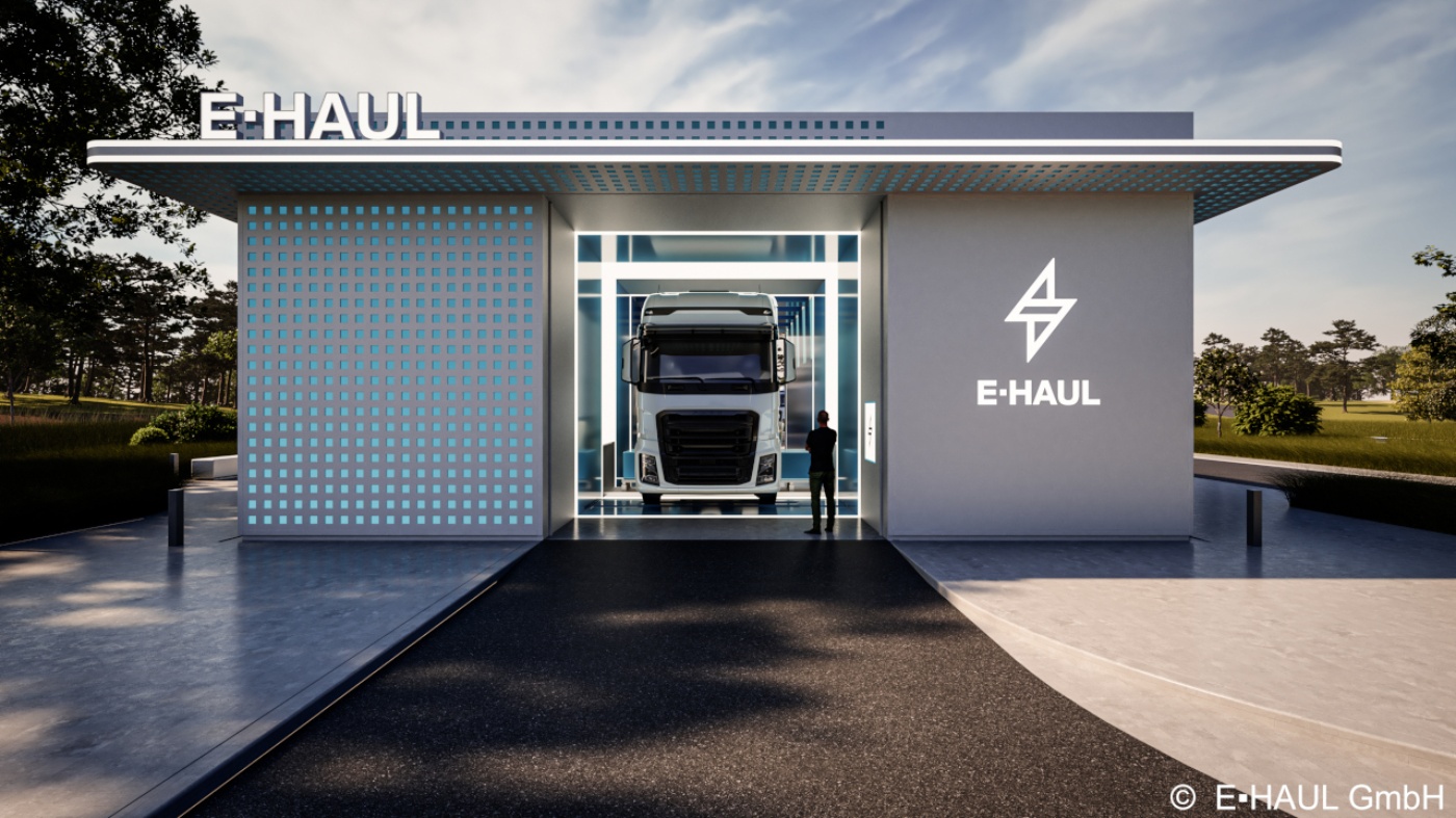 Elektro-Lkw in moderner E-HAUL-Ladestation mit einer Person davor.
