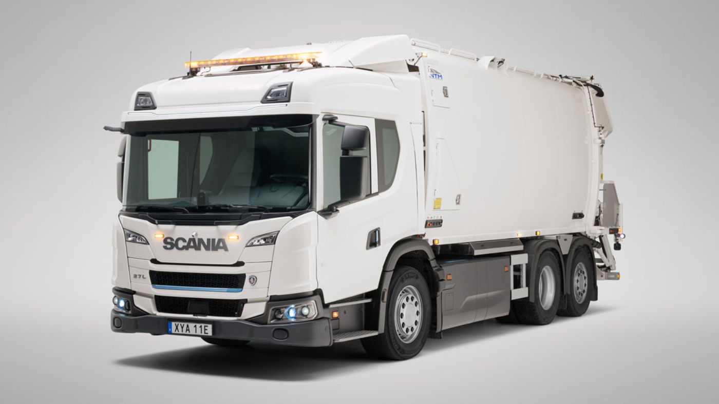 A white Scania garbage truck is parked in a studio setting with a neutral background.