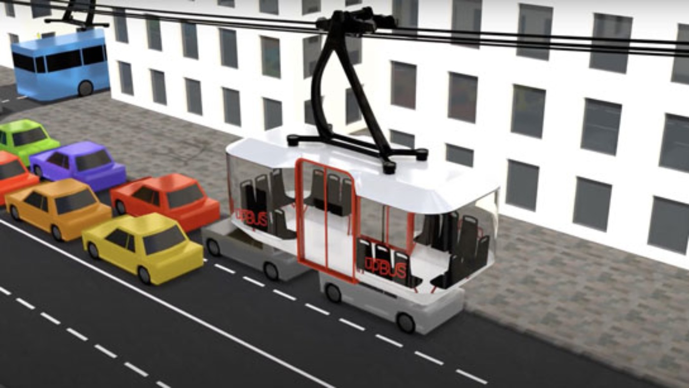 An upBUS cabin moves above a city street with colorful cars and a white building.