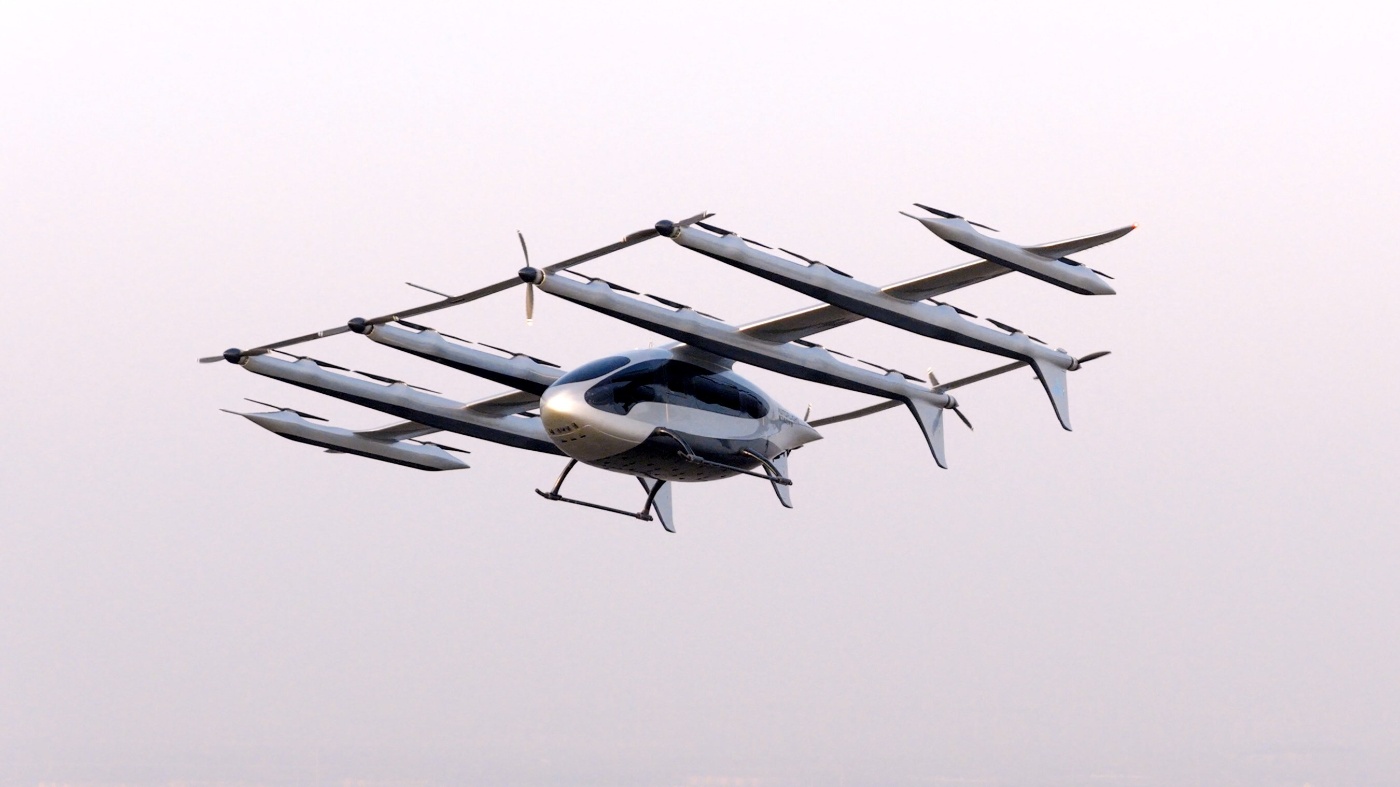 Elektrisches Lufttaxi mit mehreren Rotoren fliegt bei klarem Himmel im Testflug.
