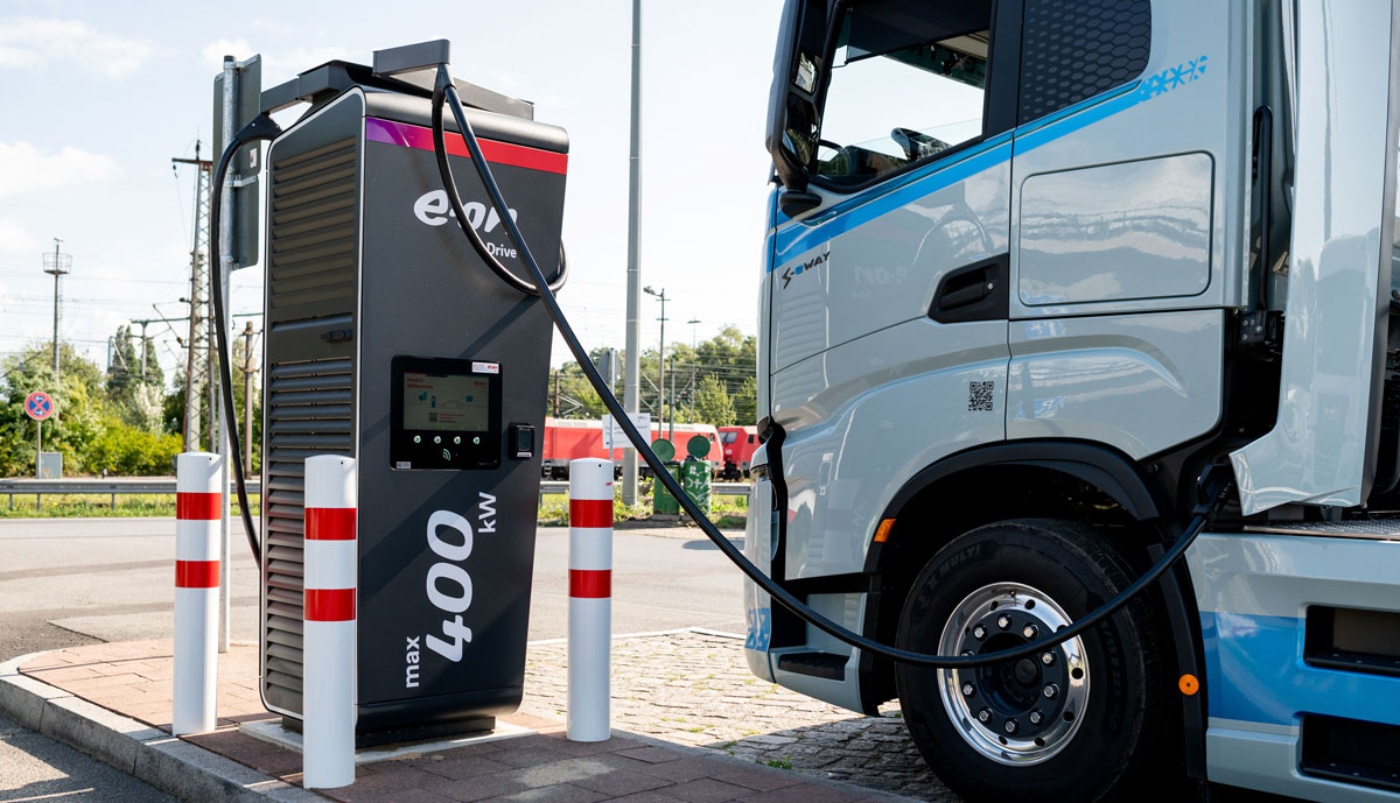 Electric truck charging at a public fast‑charging station.