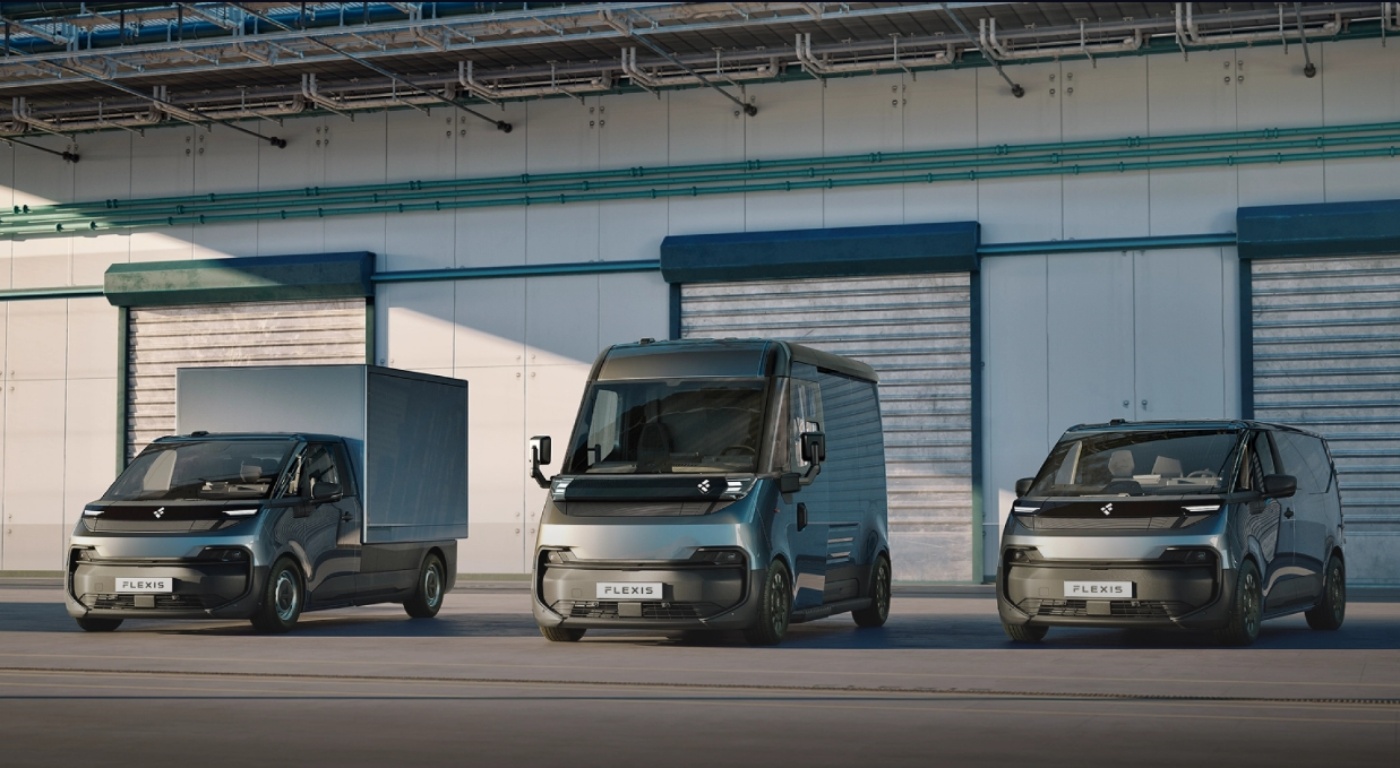 Three FLEXIS electric delivery vans parked in front of a warehouse.