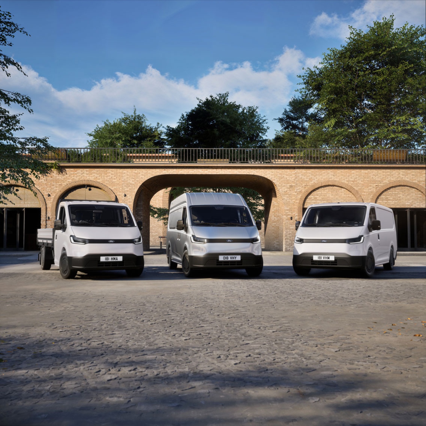 Three white vans parked in front of a brick building