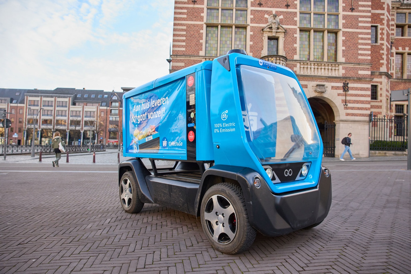 Kleines blaues Elektro-Müllfahrzeug auf einem Stadtplatz.