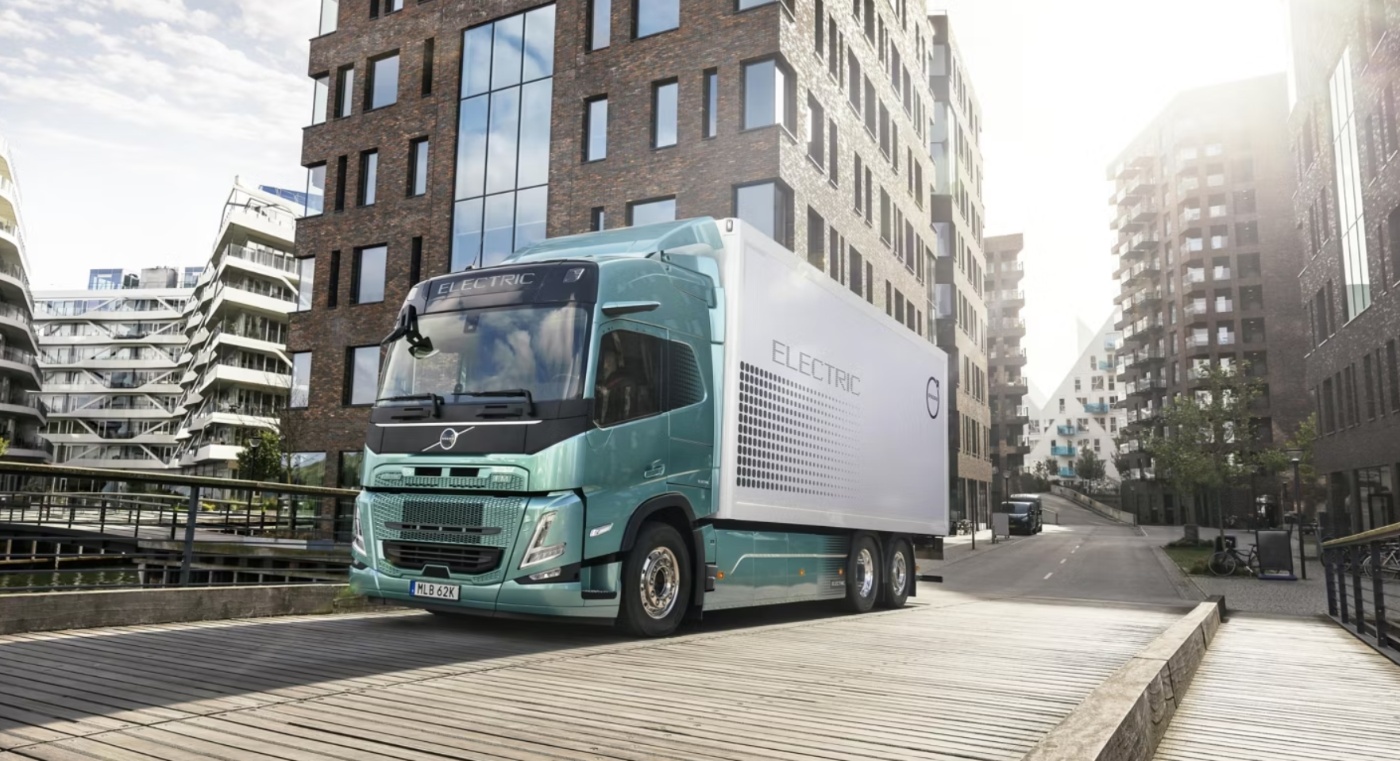 Elektrischer Volvo-Lkw fährt durch ein modernes Stadtviertel.