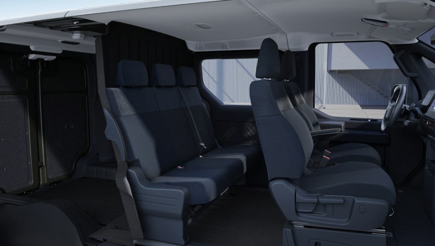 Interior of a Kia van with two seat rows and visible sliding doors.