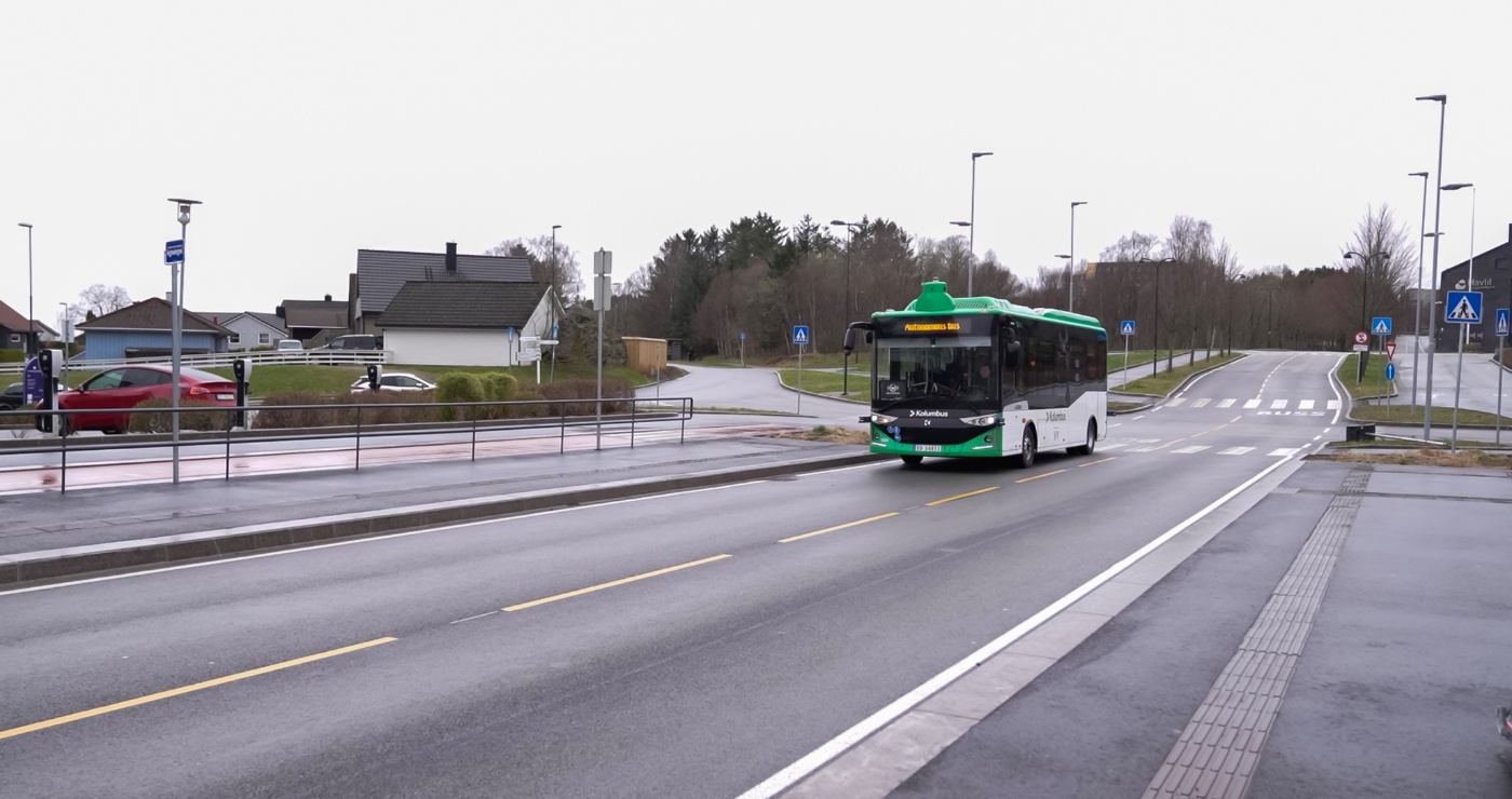 Autonomous electric bus driving on a city street.