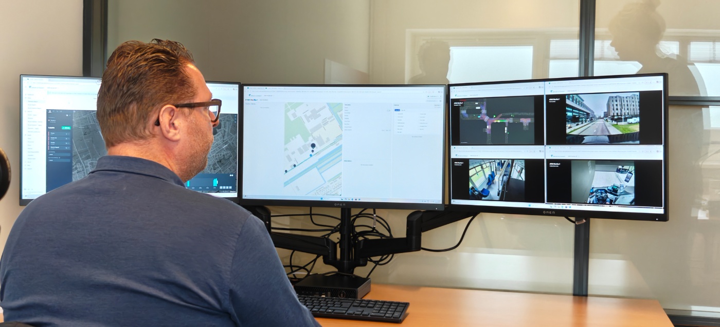 Mann überwacht Daten eines autonomen Fahrzeugs auf mehreren Bildschirmen.
