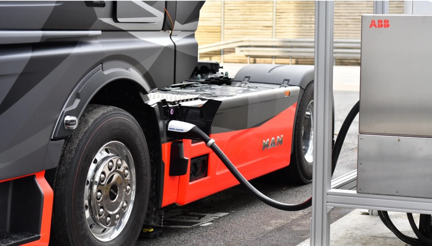 Electric truck charging from a red ground power unit.