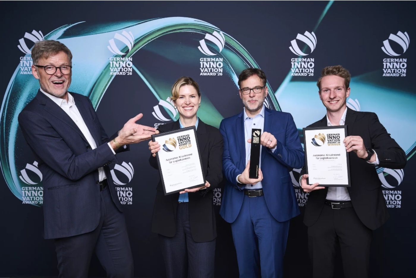Four people holding trophies and certificates at the German Innovation Award 26.