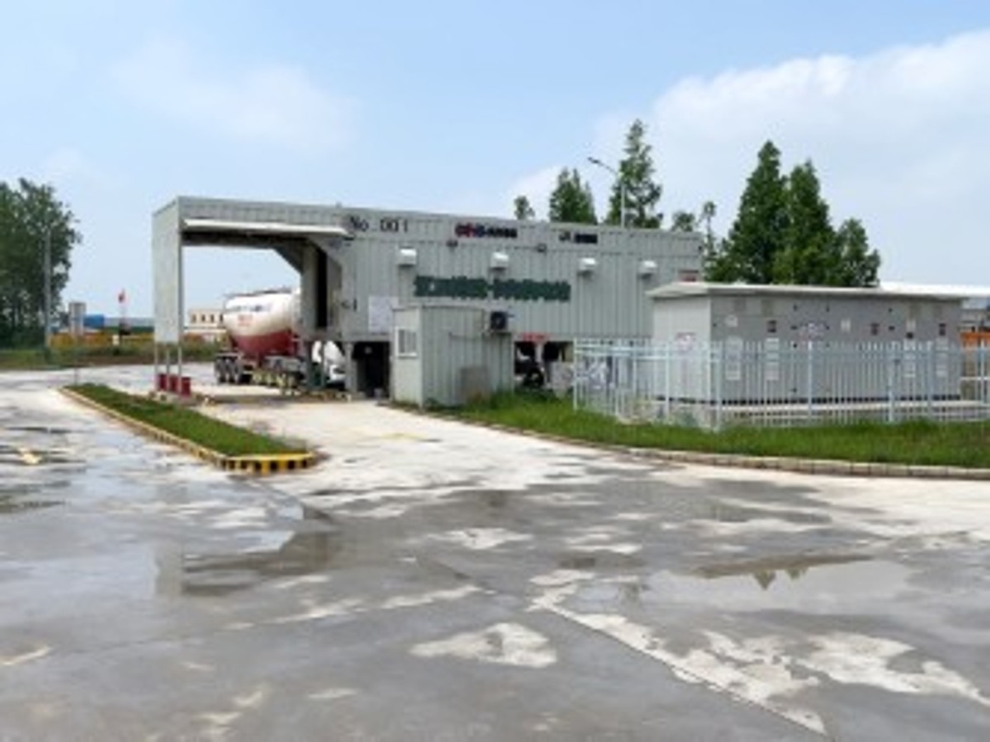 Lkw an industrieller Batteriewechselstation mit Containergebäude.