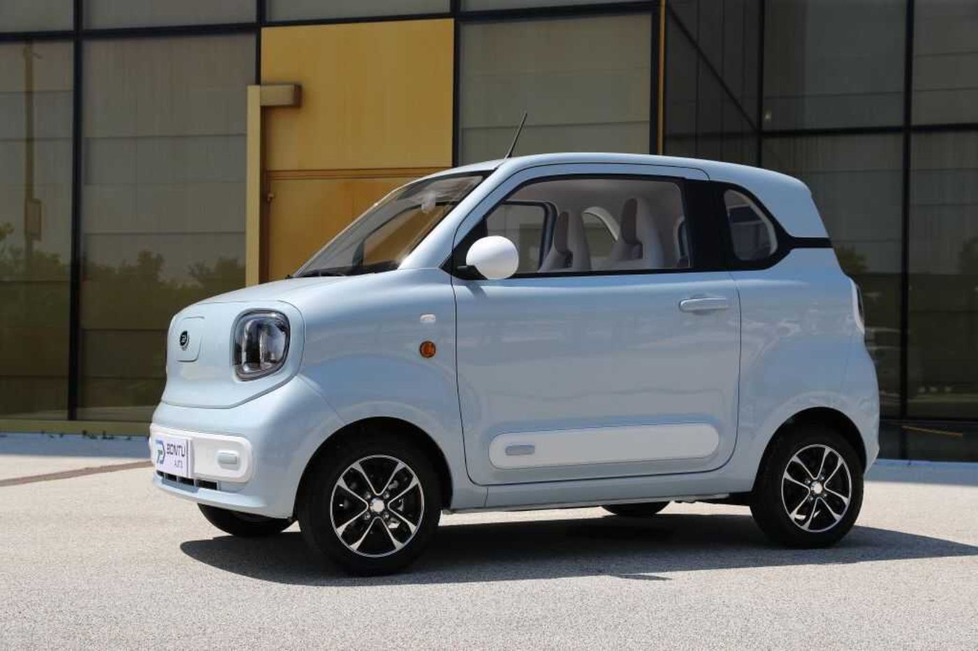 Kompaktes Elektroauto von Bontu vor einem modernen Gebäude.