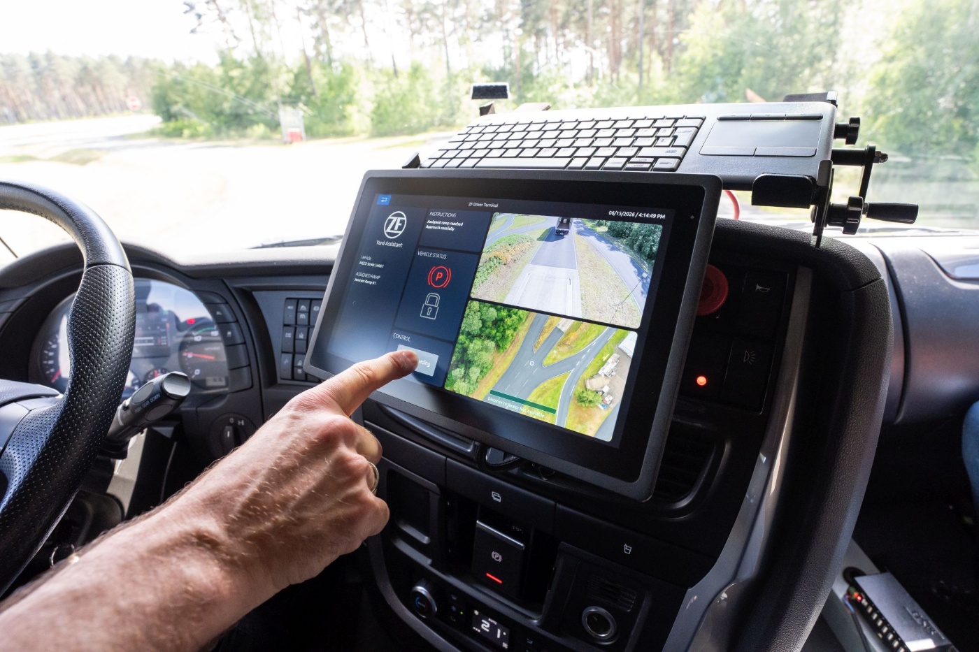 Person using a ZF driver terminal with camera views and vehicle control functions.