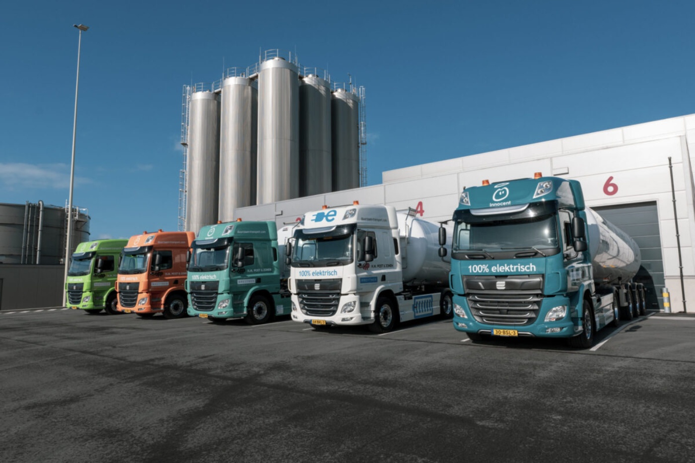 Mehrere Lastwagen stehen vor einer Industrieanlage.