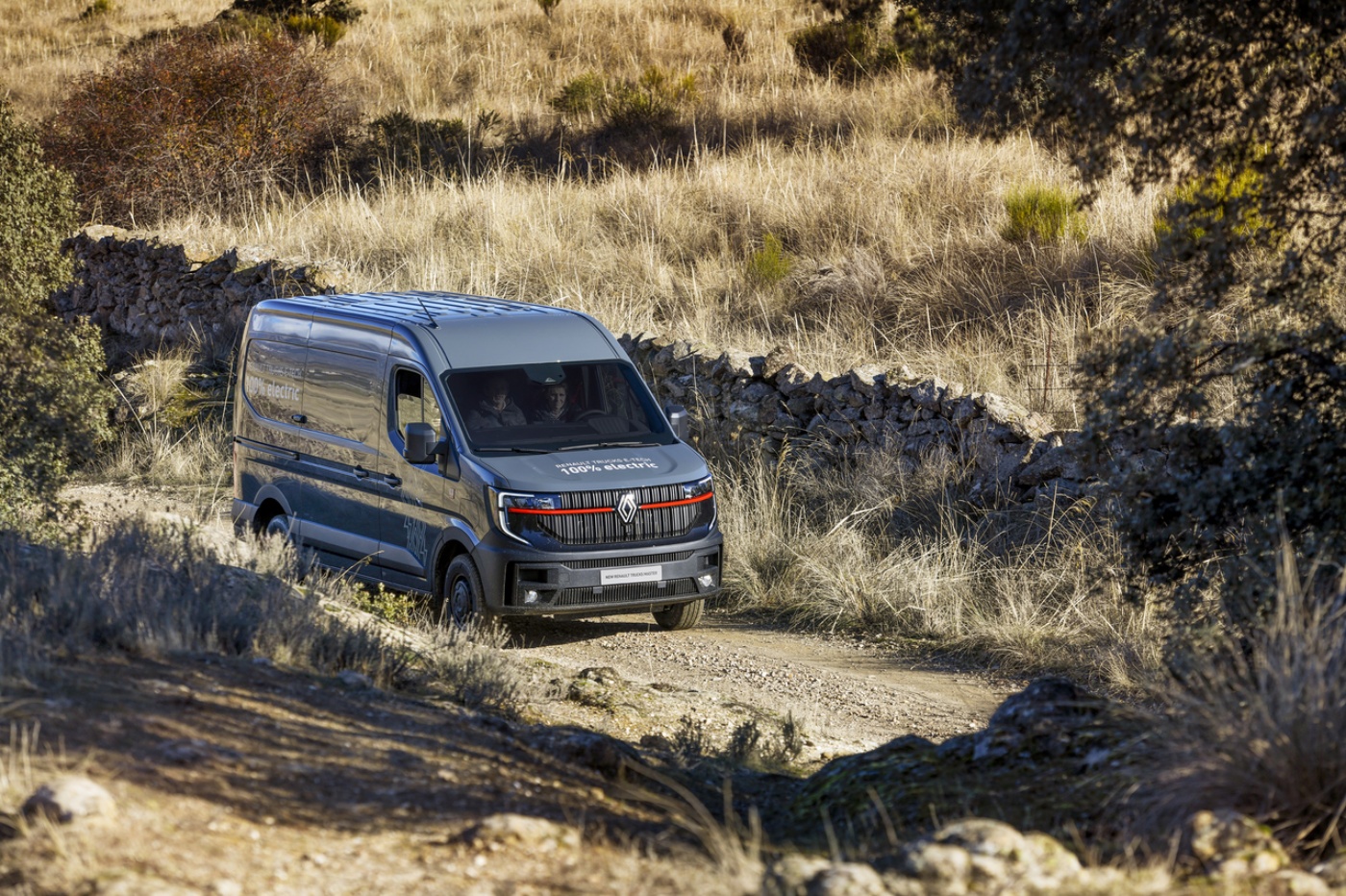 Renault Trucks E-Tech Master fährt auf einem Feldweg durch eine Landschaft.