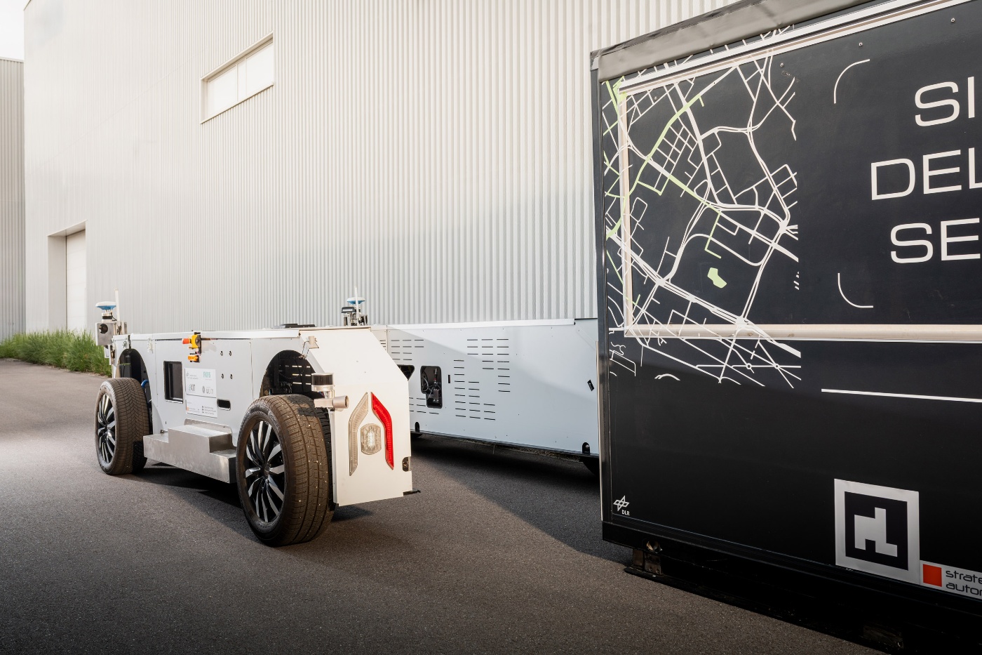U-Shift autonomous transport platform beside a modular cargo unit.
