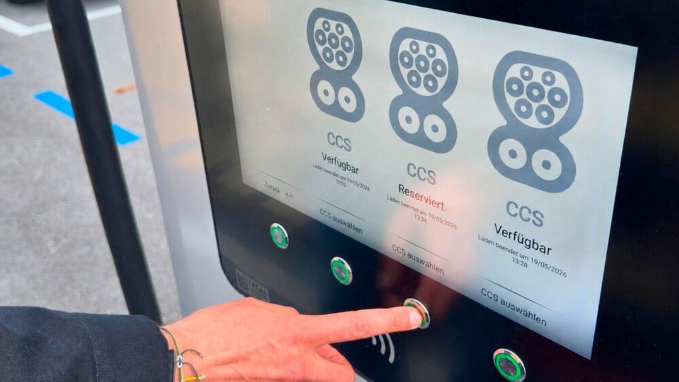 Eine Person wählt den Ladeanschluss an einer E-Ladestation aus.