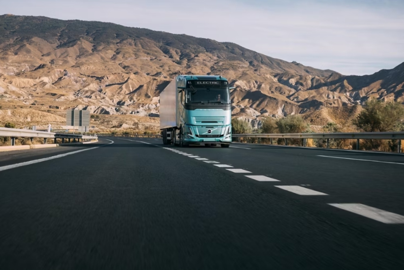 Volvo Elektro-Lkw fährt auf einer Autobahn durch eine Berglandschaft.